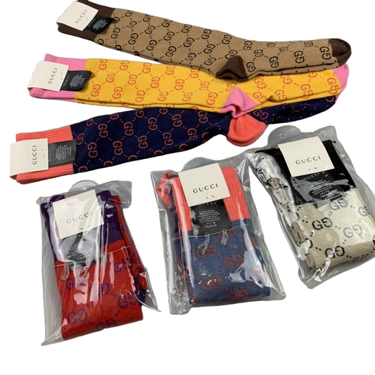 Collection of Gucci socks in various colors on a gray surface