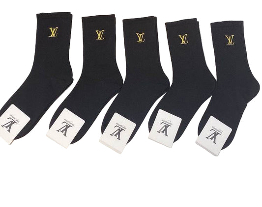 Five black socks with a logo and white labels on a white surface, with a Louis Vuitton box in the background.