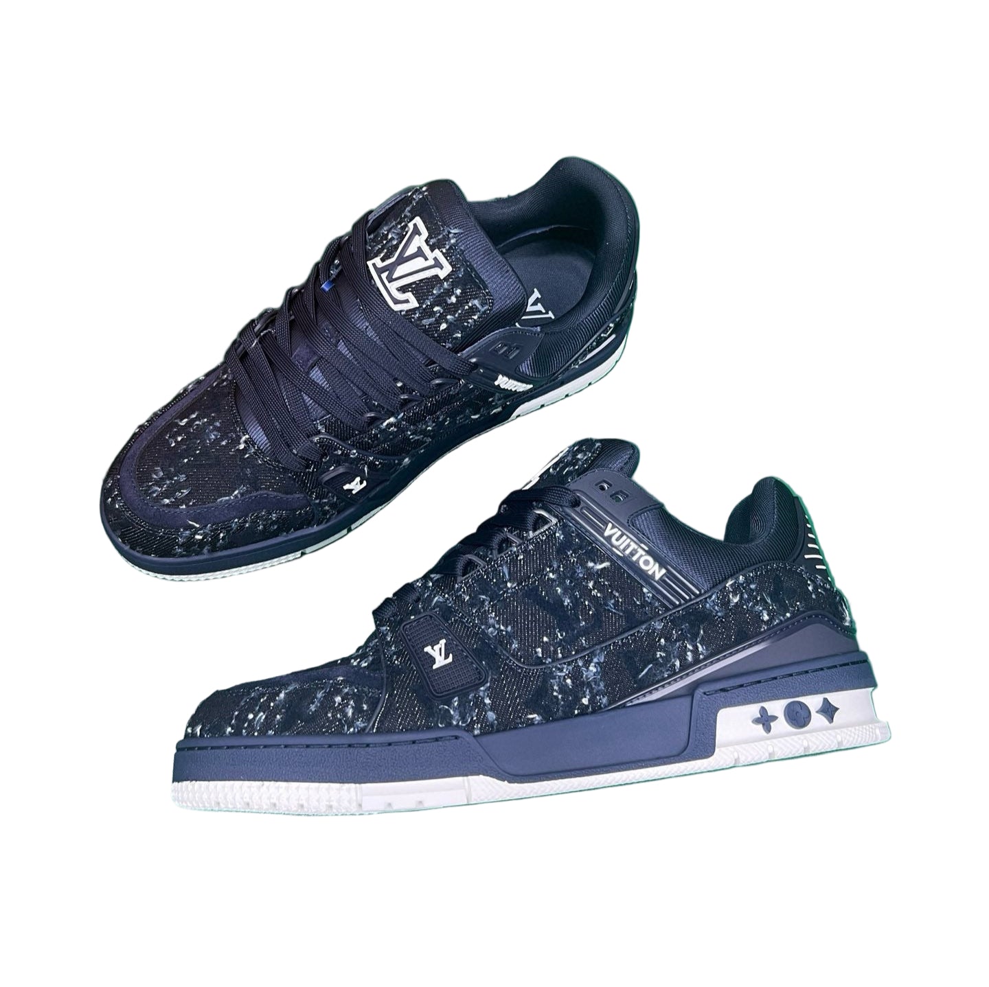 Navy blue sneakers with white soles on a green surface, next to an orange box.