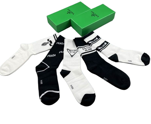 Black and white Prada socks with a green box on a gray background