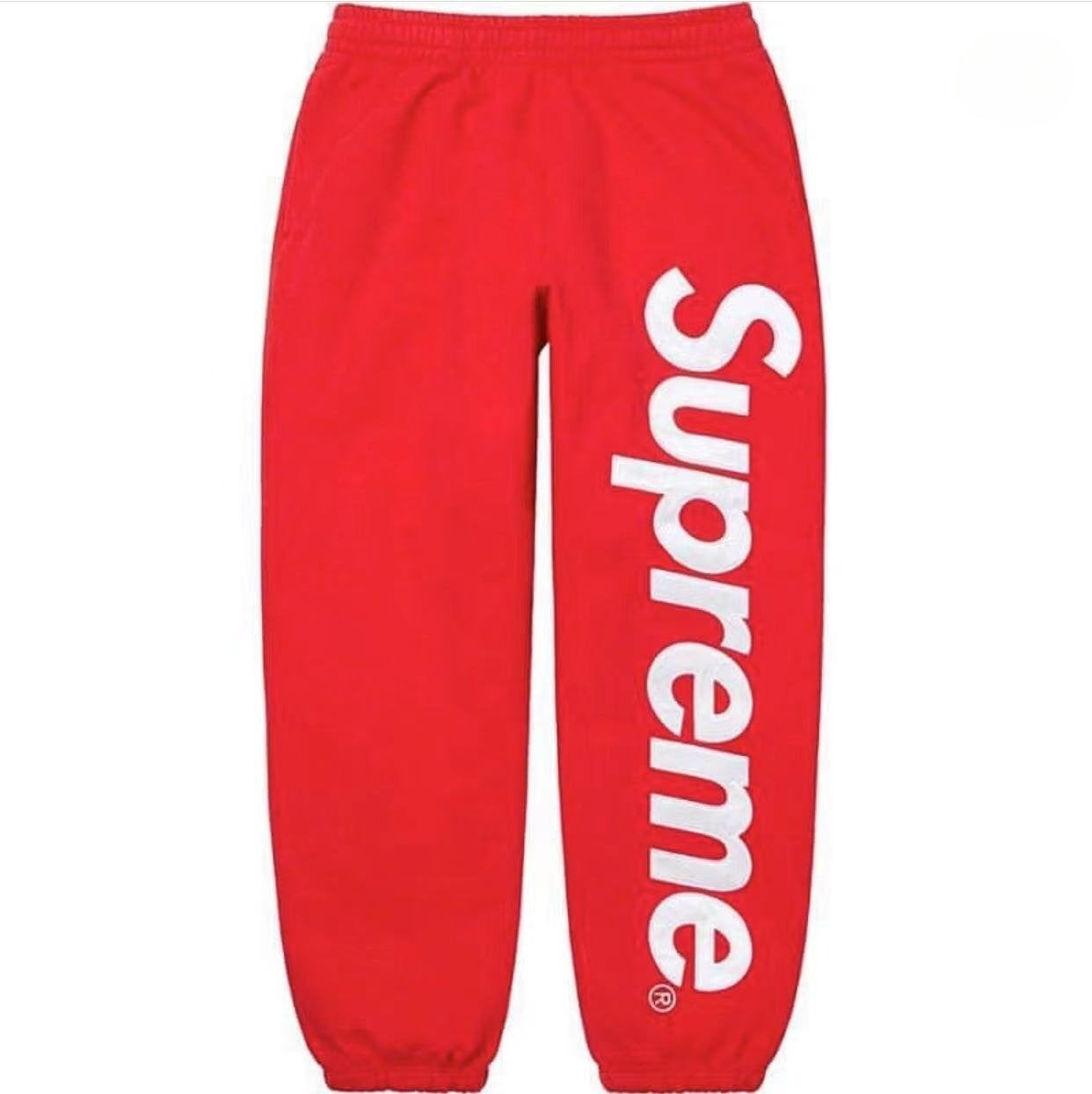 Red sweatpants with 'Supreme' logo on a white background