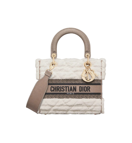Christian Dior handbag with quilted design and logo on a white background