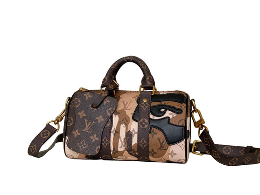 Designer handbag with unique face design on a white surface with a rabbit figurine in the background.