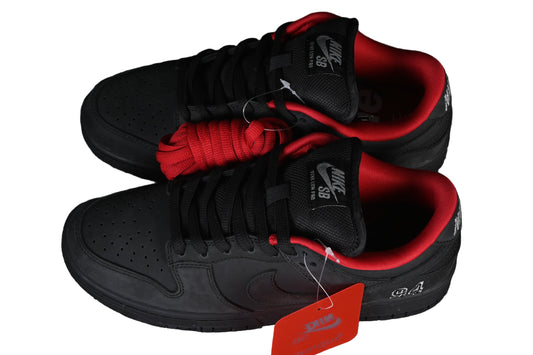 Black sneakers with red accents on a black wire mesh background