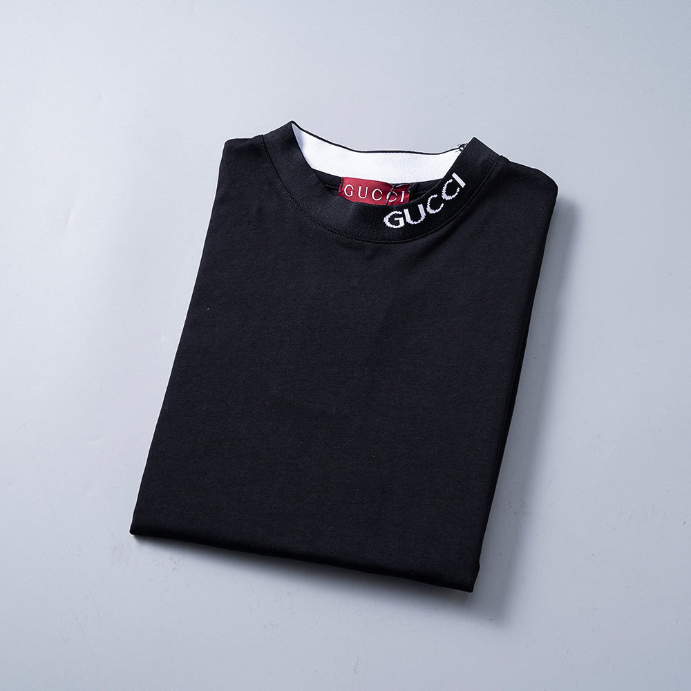 Folded black Gucci sweatshirt on a light gray background