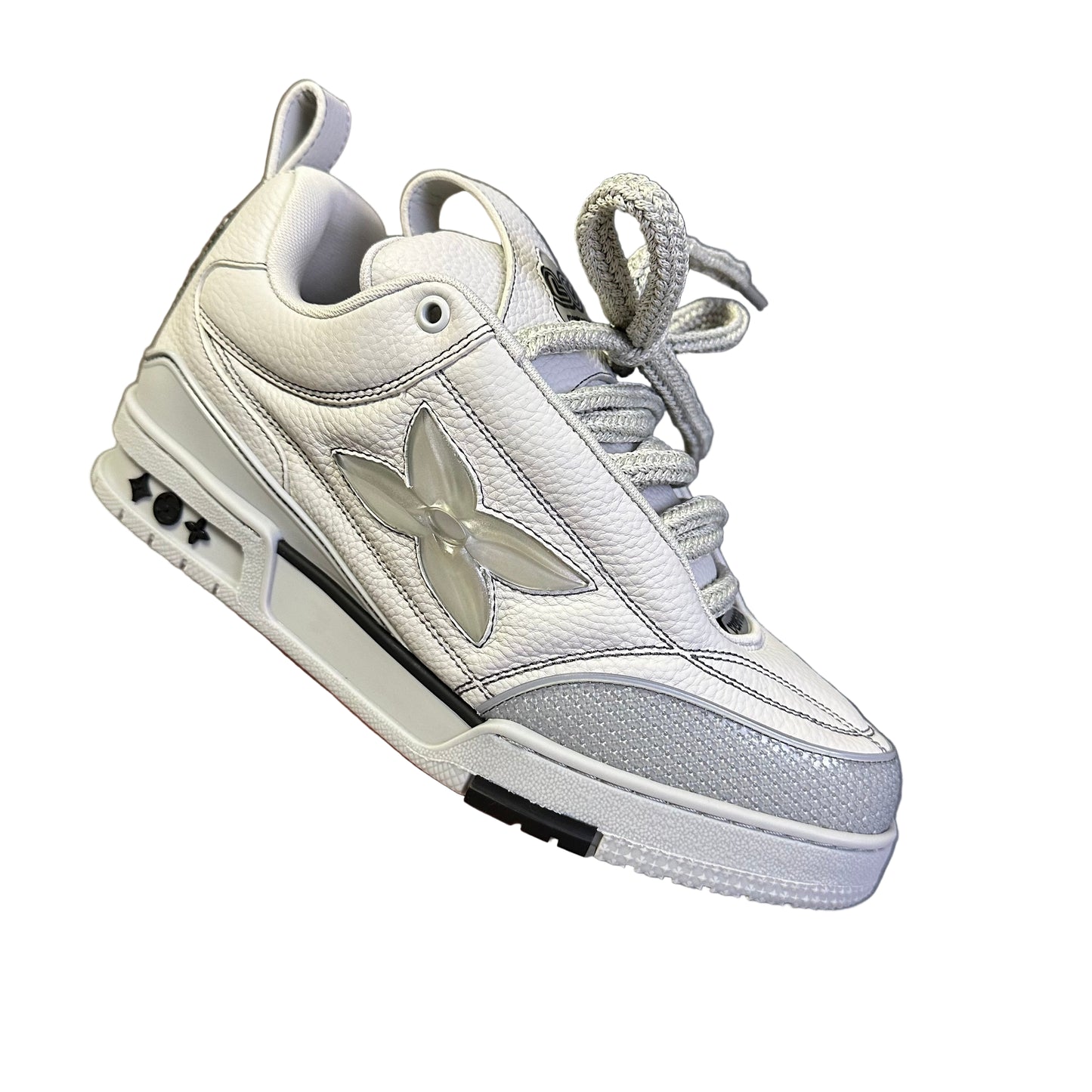 lv Gray sneaker held in a hand with a blurred background