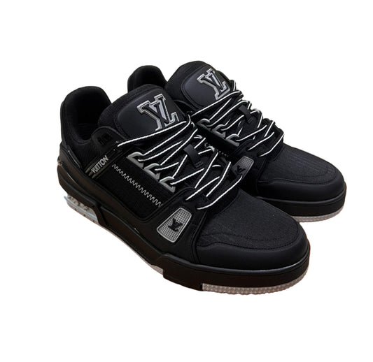 Black sneakers with white logo on an orange box, with cardboard boxes in the background.