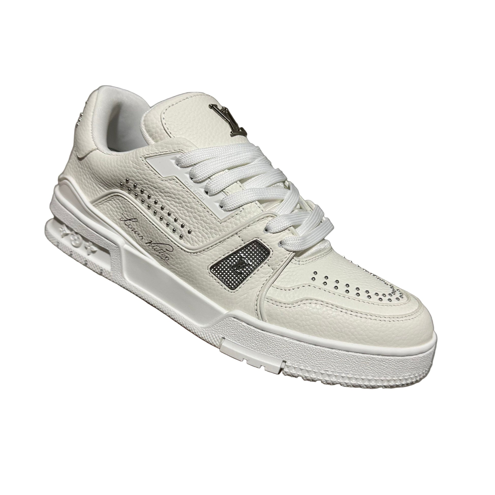 lv White sneaker held by a hand against a textured gray background