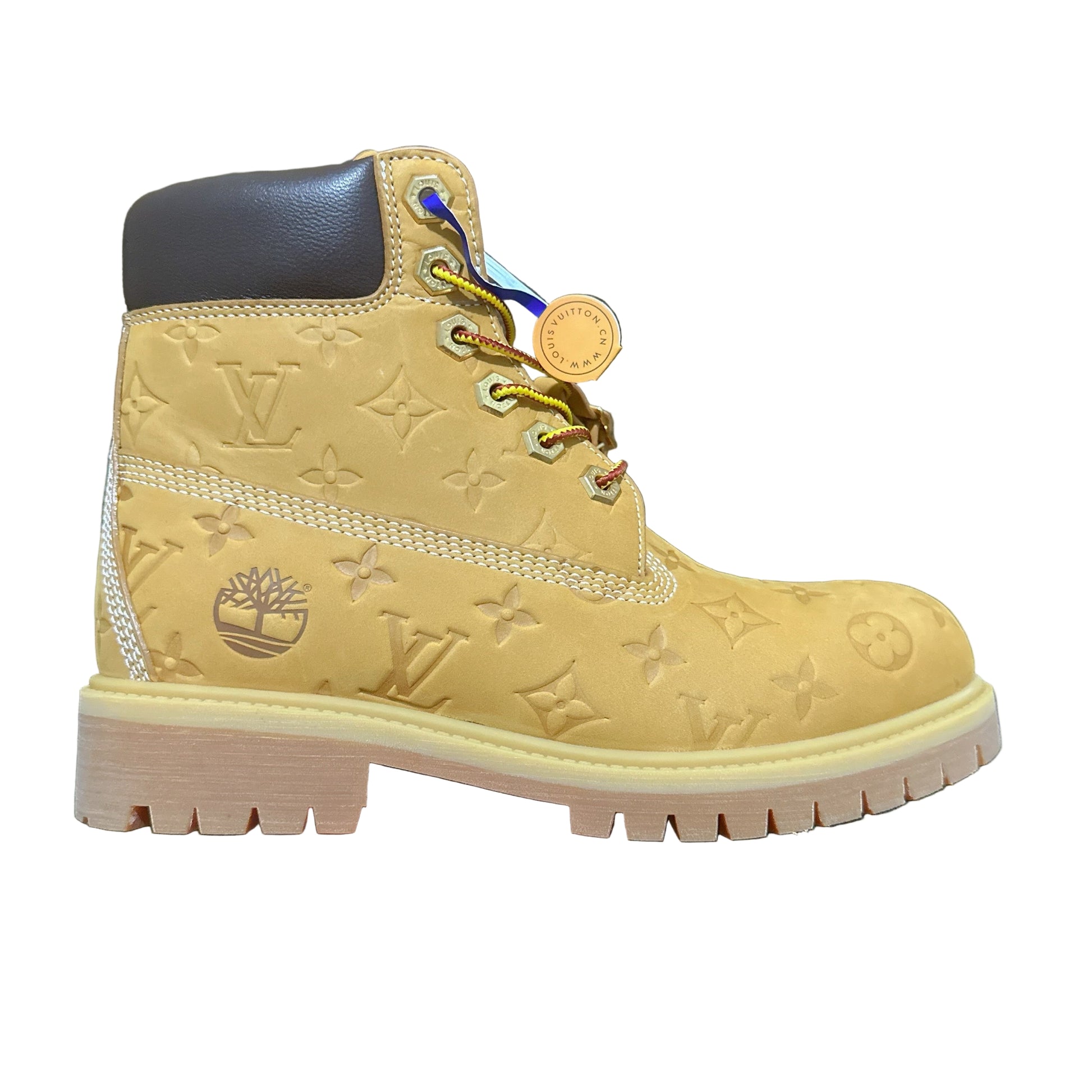 Yellow boot with brand logo held by a hand on a dark textured background