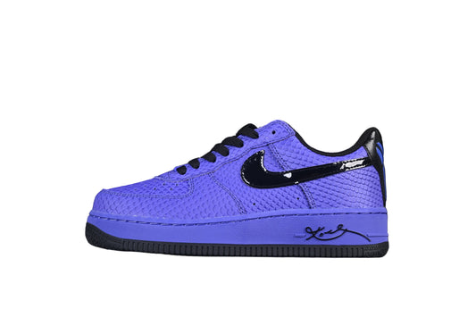Blue sneaker with black accents on a metallic surface against a dark background