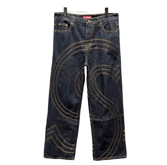 Pair of blue jeans with decorative stitching on a white background
