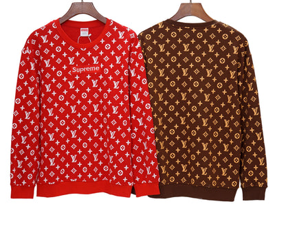 Red and brown patterned sweaters on hangers against a white background