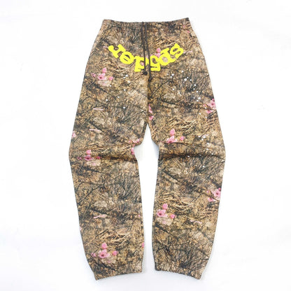 Sp5der Camouflage pants with floral patterns and yellow text on a white background