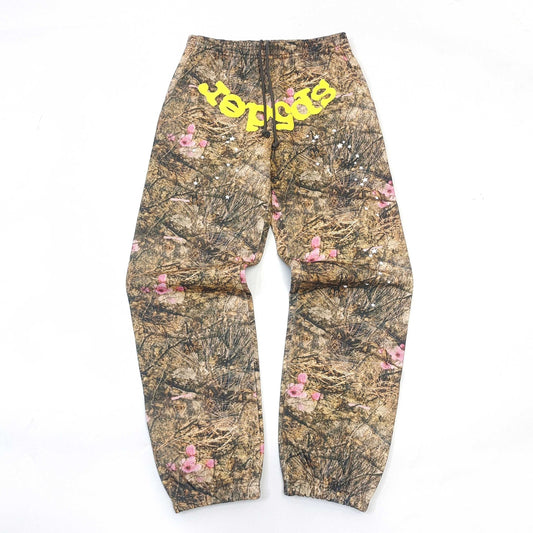 Sp5der Camouflage pants with floral patterns and yellow text on a white background