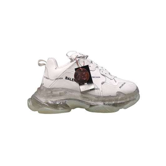White sneaker with transparent sole on a reflective surface