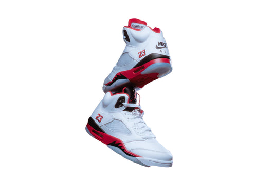 White sneakers with red and black accents on a white background